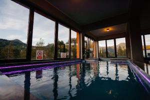 a swimming pool in a building with windows at Four S Palace in Băile Borşa