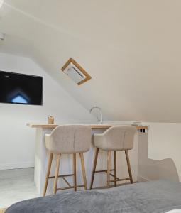 a kitchen with a counter with two stools and a sink at Dworek Góra i Kura in Brenna