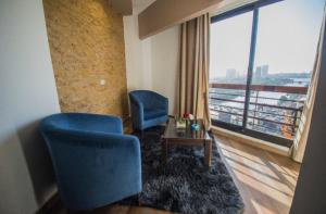 Nile Guardian Hotel في القاهرة: غرفة بها كرسيين زرقين ونافذة