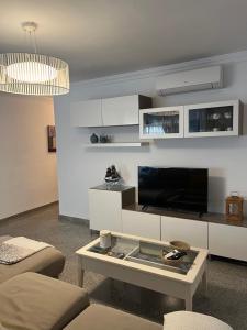 uma sala de estar com uma televisão e uma mesa de centro em Apartamento Reyes La Carihuela em Torremolinos