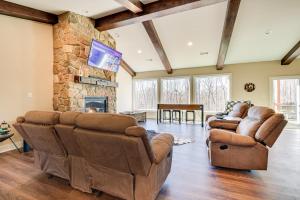 a living room with leather furniture and a stone fireplace at Home Gym and Fireplace Roaring River Retreat in Roaring River