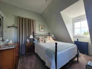 a bedroom with a bed and a window at La Coulee Verte in Saint-Aubin-de-Luigné