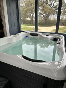 a bath tub in a room with a window at Creed's Cottage at Four Oaks in New Braunfels