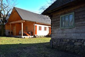 ein Haus mit einer Steinmauer neben einem Gebäude in der Unterkunft Casa Visovan in Sighetu Marmaţiei