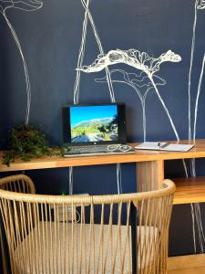 a laptop computer sitting on top of a wooden desk at Ginkgo Patagonia in El Bolsón