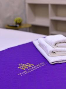 a purple towel with white towels on a table at Luxury Lazar Towers by GLAM Story in Iaşi