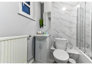 a white bathroom with a toilet and a shower at City Oasis - 1 BD Flat in Central Location in London