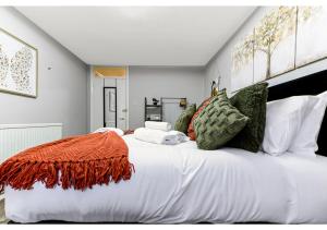 Una gran cama blanca con una manta naranja. en City Oasis - 1 BD Flat in Central Location en Londres