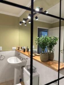 une salle de bain avec un lavabo et un miroir dans l'établissement Ginkgo Patagonia, à El Bolsón 14 autres photos