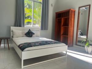 a white bed in a room with a window at Calamari Beach Resort in Zanzibar City