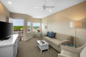 sala de estar con sofá y TV en Sanderling Resort Outer Banks, en Duck