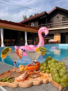 een schaal fruit en twee martini glazen naast een zwembad bij DOLINA SUNCA (Ranch Corral) in Popovača