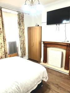 um quarto com uma cama, uma televisão e uma lareira em PEACEFUL PLACE em Nottingham