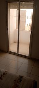 a bedroom with a sliding glass door with a window at Sousse kantaoui tunisia in Hammam Sousse