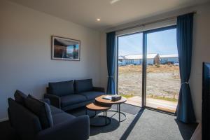 een woonkamer met een bank en een tafel bij Luminous Tekapo in Lake Tekapo