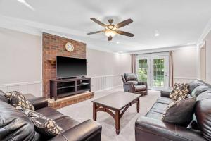 a living room with leather furniture and a flat screen tv at Beautiful Home Walking Distance to Elon University in Elon