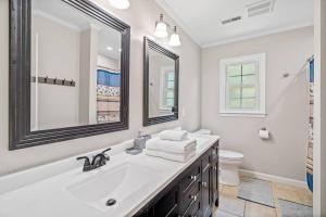 a white bathroom with a sink and a toilet at Beautiful Home Walking Distance to Elon University in Elon