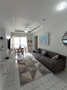 ein Wohnzimmer mit einem Sofa und einem Tisch in der Unterkunft Apartamento Aconchego na Praia da Costa in Vila Velha