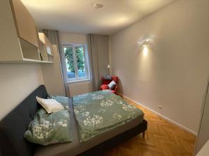 a small bedroom with a bed and a window at City Apartment Messe Graz Amélie in Graz