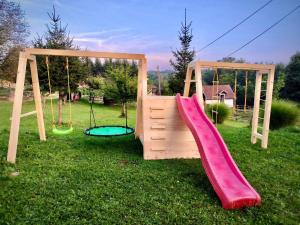 a wooden playground with a slide and swings at DOLINA SUNCA (Ranch Corral) in Popovača