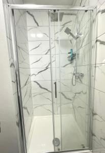 a shower with a glass door in a bathroom at 3 Bedroom fully equipped house with garden in Manchester