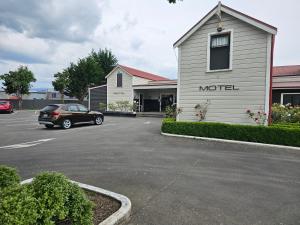 a car parked in a parking lot in front of a motel at Gateway Motor Inn in Masterton