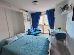 托雷莫利諾斯的住宿－Estudio Copenhague，一间卧室配有一张床、一张书桌和一个窗户。