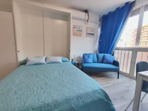 Estudio Copenhague في توريمولينوس: غرفة نوم بسرير ازرق وكرسي ازرق