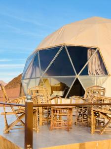 a tent with chairs and a table in the desert at Rum Four Seasons luxury camp in Wadi Rum