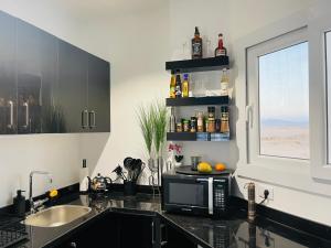 a kitchen with a microwave on a counter with a window at Private sea view Penthouse New apartment Pool and Jacuzzi in Montazah in Sharm El Sheikh
