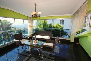 sala de estar con mesa, sillas y ventanas grandes en Villa - Luxus - Pool - Whirlpool - Alanya - Kestel, en Alanya