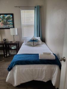 1 dormitorio con 1 cama grande y cortina azul en House of Favor, en Redding