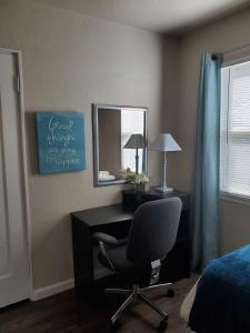 a bedroom with a desk and a chair and a mirror at House of Favor in Redding
