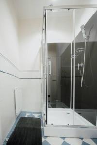 - przeszklony prysznic w łazience z czarnym dywanem w obiekcie P77 Central New 4-Bedrooms Piotrkowska CAŁE MIEJSCE 4 pokoje z łazienką i kuchnią na korytarzu budynku w Łodzi