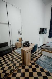 Pokój z biurkiem i łóżkiem oraz podłogą wyłożoną szachownicą w obiekcie P77 Central New 4-Bedrooms Piotrkowska CAŁE MIEJSCE 4 pokoje z łazienką i kuchnią na korytarzu budynku w Łodzi