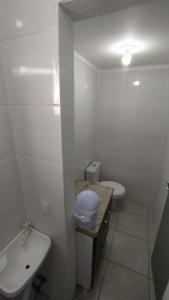 La salle de bains blanche est pourvue de toilettes et d'un lavabo. dans l'établissement Coração de Balneário Camboriú, à Balneário Camboriú