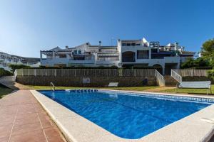 a swimming pool in front of a large house at Loft del Sol in Peniscola