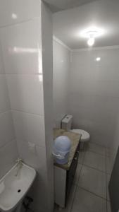 La salle de bains blanche est pourvue d'un lavabo et de toilettes. dans l'établissement Coração de Balneário Camboriú, à Balneário Camboriú