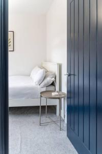 ein Schlafzimmer mit einem Bett mit einem Stuhl und einem Tisch in der Unterkunft Luxury in the City Centre 2 Bed by Home Host in Cardiff