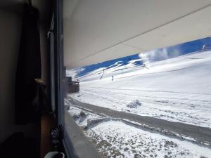 uma vista para uma encosta coberta de neve a partir de uma janela de comboio em Studio Cosy-Aux pieds des pistes-2100 m em Aime La Plagne