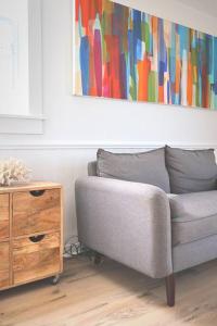 um sofá e uma cómoda numa sala de estar com um quadro em The Summerhouse @ Saint Peters em Saint Peters