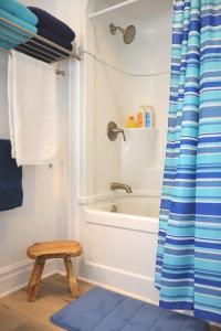 uma casa de banho com uma banheira e um banco ao lado de um chuveiro em The Summerhouse @ Saint Peters em Saint Peters