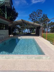 una piscina con una sombrilla encima en Casa árbol, en Aguas Zarcas