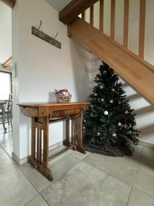 a christmas tree sitting next to a wooden table at Duplex au cœur de l’Alsace in Muttersholtz