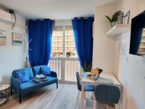 Estudio Copenhague في توريمولينوس: غرفة معيشة مع أريكة زرقاء وطاولة