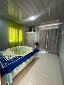 a bedroom with a bed and yellow curtains at Sitio in Novo Hamburgo