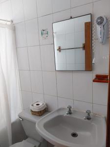 a bathroom with a sink and a toilet and a mirror at Refugio Humboldt in Punta de Choros