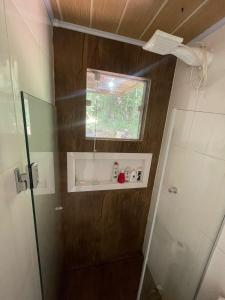 uma pequena casa de banho com um chuveiro e uma janela em Sitio em Novo Hamburgo
