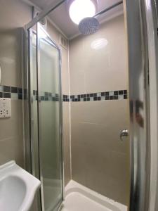 a bathroom with a shower and a sink at THE ROYAL BOUTIQUE TRAFALGAR LODGE BY LONDON HEATHROW UK, PRIVATE HOME OFFER's FREE PARKING, WIFI , KITCHEN, GARDEN & LAUNDRY SERVICES, SLEEP 10 in Northolt