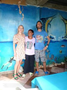 a man and a woman standing in front of a mural at HOSTAL BELLEZA TROPICAL in Moñitos